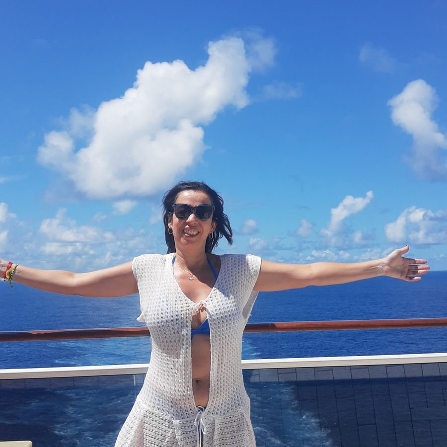 Josiane de braços abertos no convés, em alto-mar